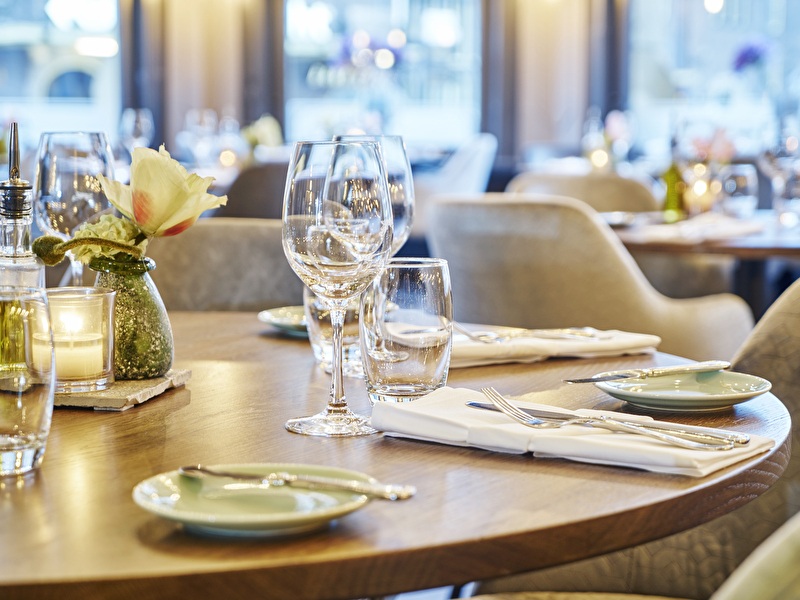 Sfeervol gedekte tafel in het restaurant van Amrâth Grand Hotel de l’Empereur in Maastricht.